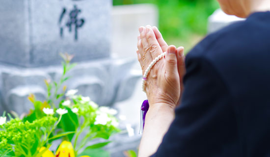 お墓の前で手を合わせている様子